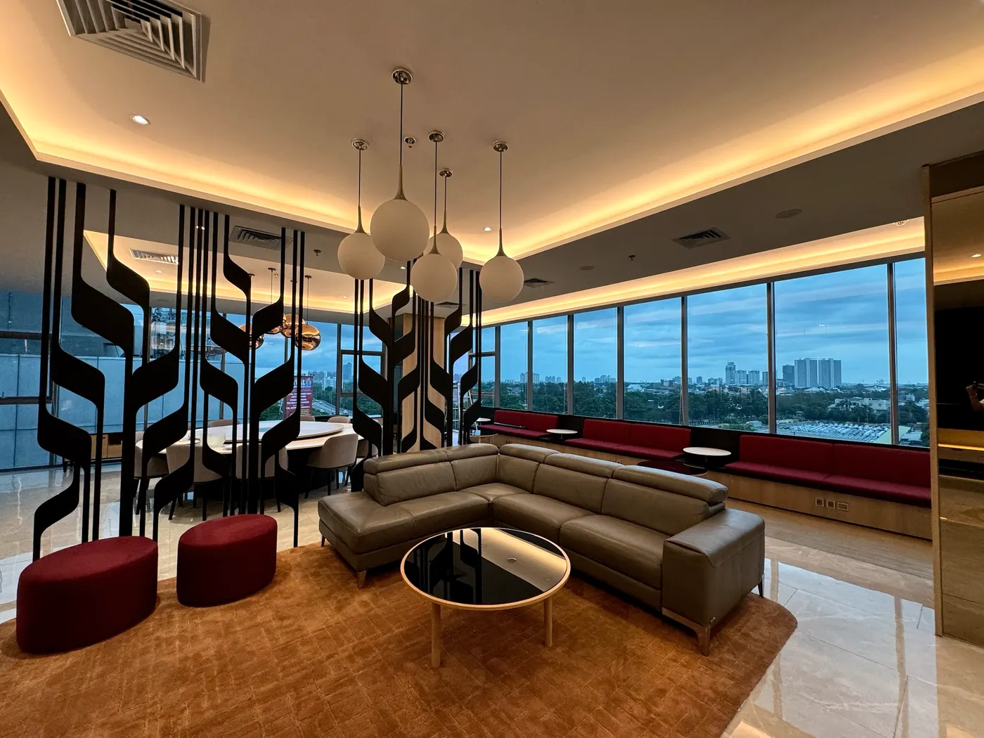 Lounge eksekutif di gedung perkantoran Jakarta dengan film pada dinding kaca dari lantai sampai plafon
