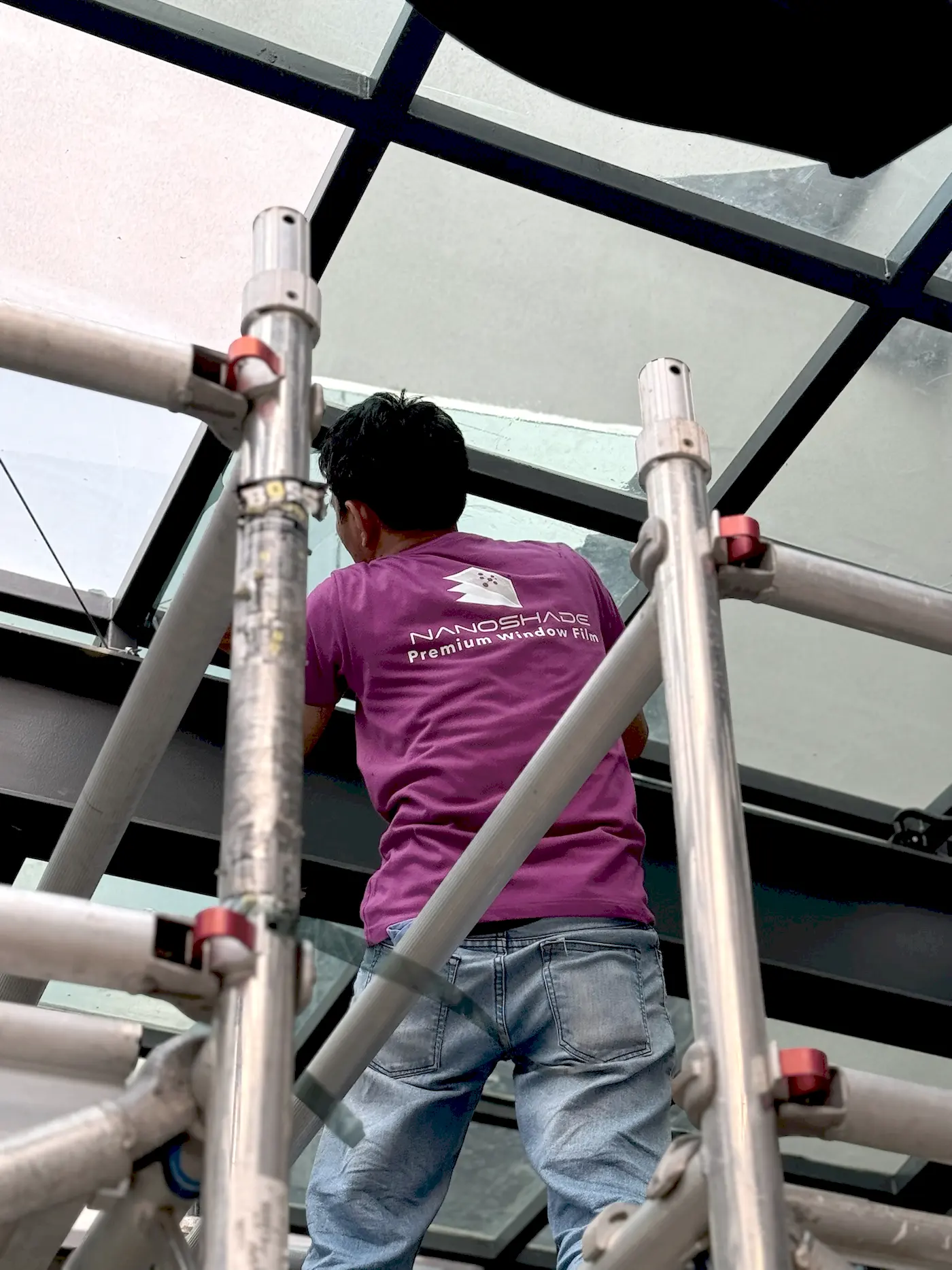 Teknisi NanoShade di atas scaffolding memasang film pada kaca skylight di TopGolf Fatmawati Jakarta