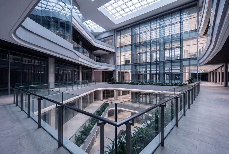 Ilustrasi: railing kaca setinggi penuh dan etalase ritel di atrium pusat perbelanjaan modern